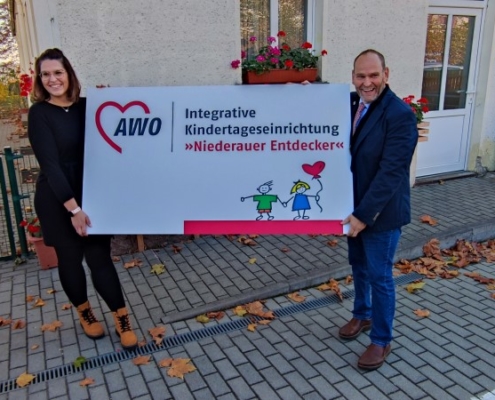 Namensschild päsentiert von Kita-Leiterin und Bürgermeistern